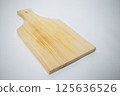 Natural wood chopping board with a handle, ideal for slicing vegetables or serving cheese. 125636526