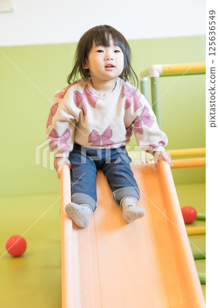 Japanese girl playing on a slide 125636549