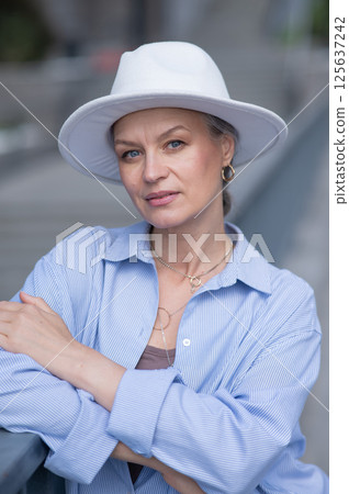 Portrait of stylish mature woman in white hat.  125637242