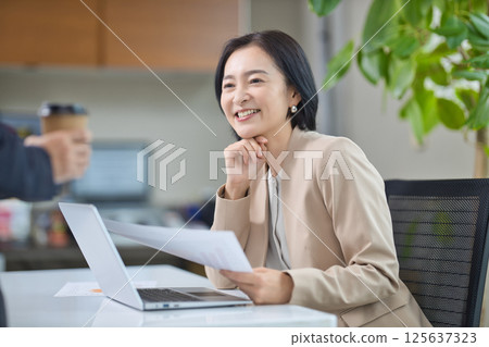 Middle-aged woman having a meeting in the office Middle-aged woman having a meeting in the office 125637323
