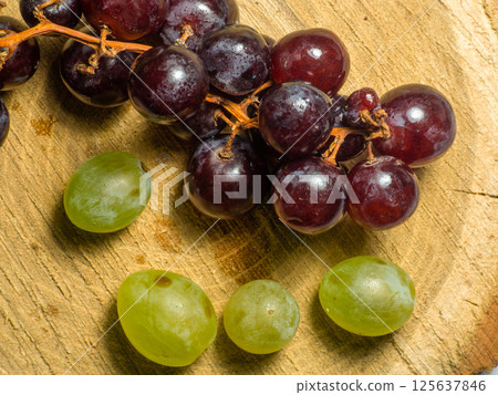 Grapes kishmish on a wooden background. The grapes are overripe. Harvest in the village. 125637846