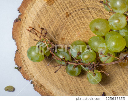 Grapes kishmish on a wooden background. The grapes are overripe. Harvest in the village. Grapes kishmish on a wooden background. The grapes are overripe. Harvest in the village. 125637855