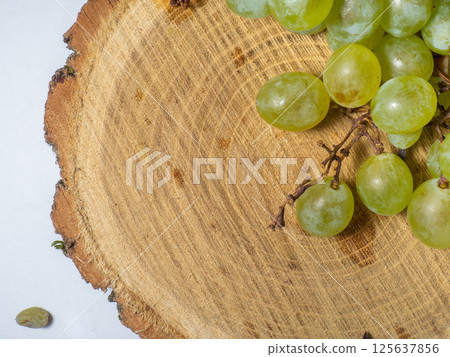 Grapes kishmish on a wooden background. The grapes are overripe. Harvest in the village. Grapes kishmish on a wooden background. The grapes are overripe. Harvest in the village. 125637856