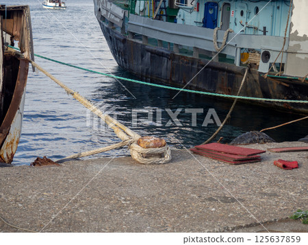 Mooring tied to the bollard. Maritime business. The concept of the ship on the pier. Ship parking. Mooring tied to the bollard. Maritime business. The concept of the ship on the pier. Ship parking. 125637859
