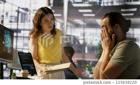 Exhausted developer caught asleep at desk by manager while developing AI machine learning company tech. Supervisor waking up tired sleeping employee while training predictive models, camera A 125638220