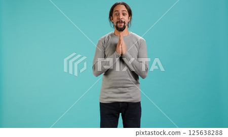Chipper joyful man happily clapping hands, eager to receive good news. Excited person cheering, applauding, feeling hopeful and keen, isolated over studio background, camera A 125638288