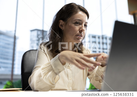 Young business entrepreneur pitching a new project idea to shareholders via videocall, discussing about investing more funds for global expansion. Female CEO with determination for growth. Young business entrepreneur pitching a new project idea to shareholders via videocall, discussing about investing more funds for global expansion. Female CEO with determination for growth. 125638331