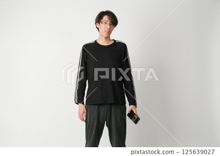 一位穿著休閒服、戴著眼鏡的男士的肖像,他微微傾斜著頭,慈祥地凝視著 一位穿著休閒服、戴著眼鏡的男士的肖像,他微微傾斜著頭,慈祥地凝視著 125639027