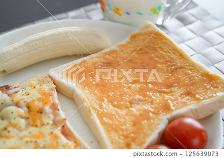 早餐包括塗滿牛奶果醬的烤麵包，配上番茄和香蕉 125639073