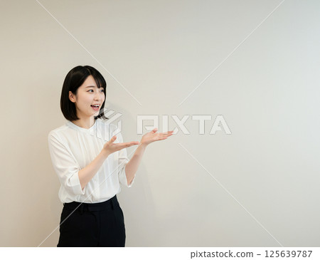 A beautiful Japanese woman explaining while gesturing with both hands 125639787
