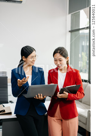 Kind leader executive manager share and discuss business solutions plan ideas on tablet with Asian female marketing manager 125640011