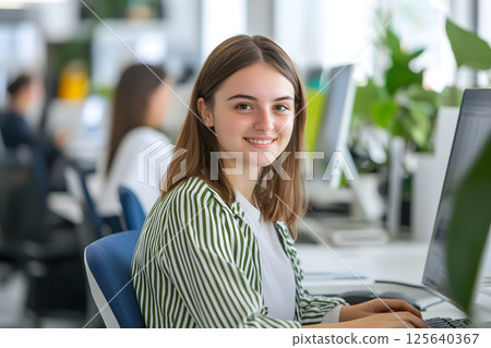 外國女人微笑。一位年輕女子在明亮的教室裡使用電腦工作的肖像 125640367