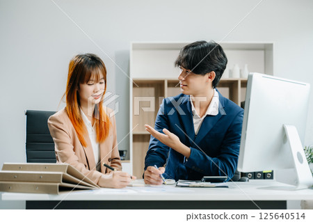Two Asian businesswoman and man discuss investment project working and planning strategy 125640514