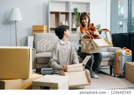 Happy asian young attractive couple man and woman with big boxes moving into a new house, new apartment Happy asian young attractive couple man and woman with big boxes moving into a new house, new apartment 125640549