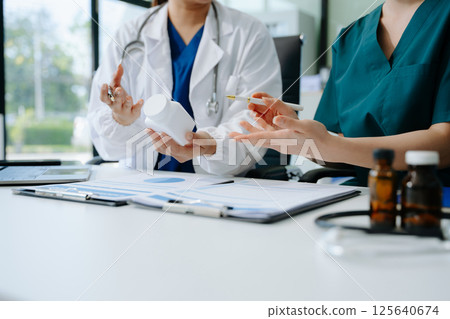 Doctors and nurses collaborate on medical treatment and prescription plans, analyzing data Doctors and nurses collaborate on medical treatment and prescription plans, analyzing data 125640674