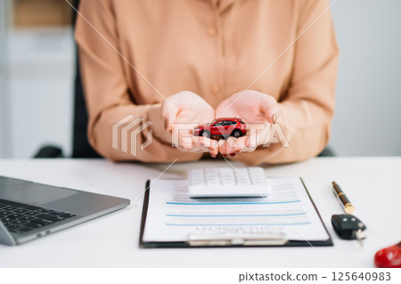 Asian people car salesman or sales manager offers to sell a car and explains of signing a car contract and signing car Asian people car salesman or sales manager offers to sell a car and explains of signing a car contract and signing car 125640983