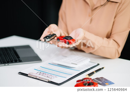 Asian people car salesman or sales manager offers to sell a car and explains of signing a car contract and signing car Asian people car salesman or sales manager offers to sell a car and explains of signing a car contract and signing car 125640984