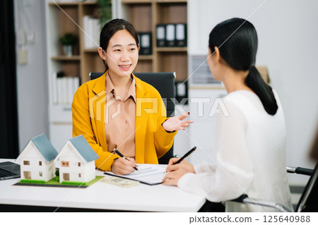 Real estate broker agent presenting and consult to customer to decision making sign insurance form agreement, home 125640988