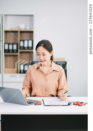 Asian people car salesman or sales manager offers to sell a car and explains of signing a car contract and signing car Asian people car salesman or sales manager offers to sell a car and explains of signing a car contract and signing car 125641029