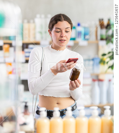 Female buyer scans code on cough syrup to check expiration date Female buyer scans code on cough syrup to check expiration date 125641657