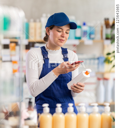 Young woman worker scanning qr code of cream 125641665