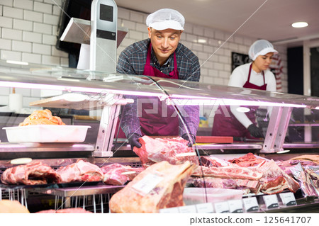Young male butcher showing big piece of beef meat in butchery 125641707