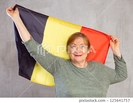 Cheerful senior woman standing confidently with belgian flag 125641757