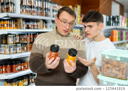 Young guy tells man what delicious spices to buy from supermarket Young guy tells man what delicious spices to buy from supermarket 125641819