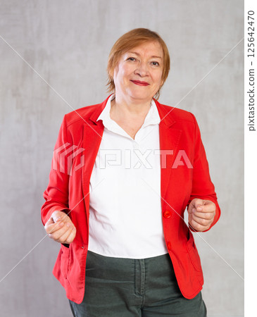 Older woman standing proudly with happy confident grin Older woman standing proudly with happy confident grin 125642470