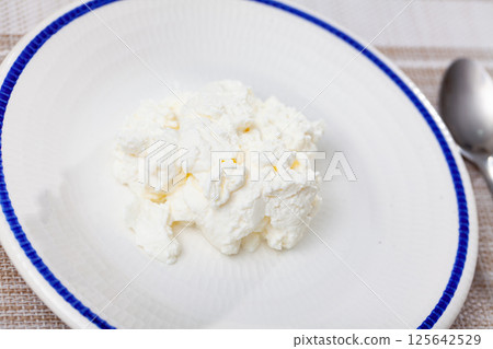 Fresh cow milk cottage cheese on plate ready to eat 125642529