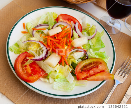 Salad of fresh lettuce, tomatoes, onion, carrot and white asparagus 125642531