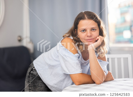Smiling girl at home interior, posing on camera 125642583