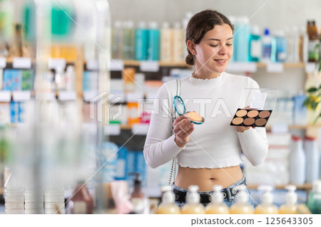 Woman choosing a palette with powder in the pharmacy Woman choosing a palette with powder in the pharmacy 125643305