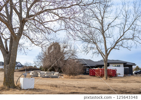 Portable gas storage at a residential building construction site with material stockpiles  125643348