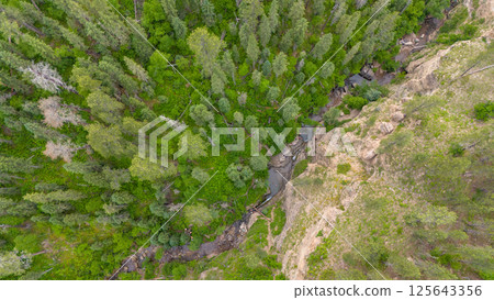 Drone view above people sliding in the Devils Bathtub waterfall and pool in Spearfish Canyon, South Dakota 125643356