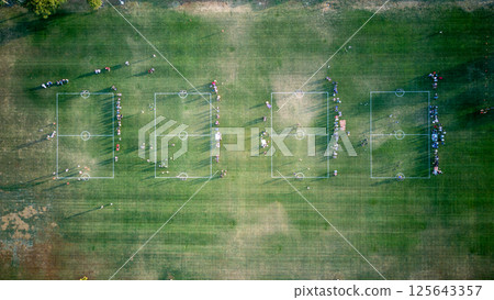 Overhead view of a youth soccer league with multiple fields in play. 125643357