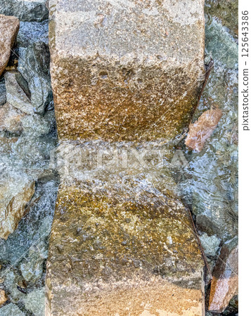 Top view of a V-notch weir cut into a concrete retaining wall for water restriction  125643386