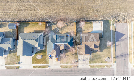 aerial view above a re-roofing overlay project at a residential house where new shingles are placed on top of existing tiles.  125643415