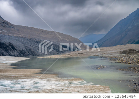 Lower edge of the Athabasca Glacier in Jasper National Park where meltwater flows off the ice 125643484