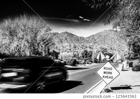 Motion blurred vehicle traveling past a road work sign for construction. 125643561