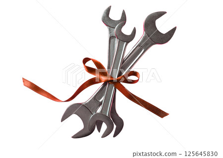 Wrenches tied with a ribbon represent Labor Day and its significance, isolated on white 125645830