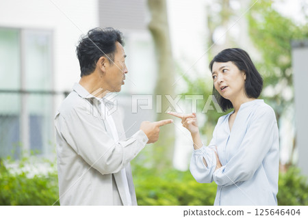 Middle-aged couple arguing in the park Middle-aged couple arguing in the park 125646404