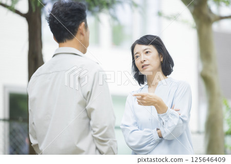 Middle-aged couple arguing in the park Middle-aged couple arguing in the park 125646409