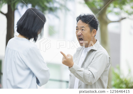 中年夫婦在公園裡爭吵 中年夫婦在公園裡爭吵 125646415