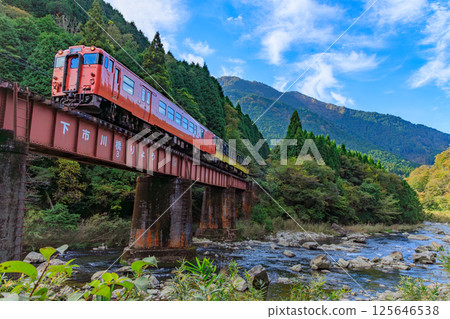 一輛橘色的播但線柴油列車正穿越下市川大橋 125646538