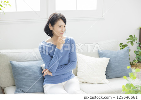 Middle woman worried in the living room Middle woman worried in the living room 125646661