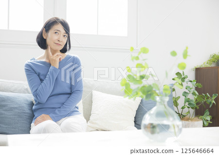 Middle woman worried in the living room 125646664