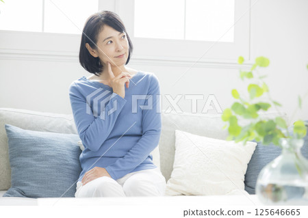 Middle woman worried in the living room 125646665
