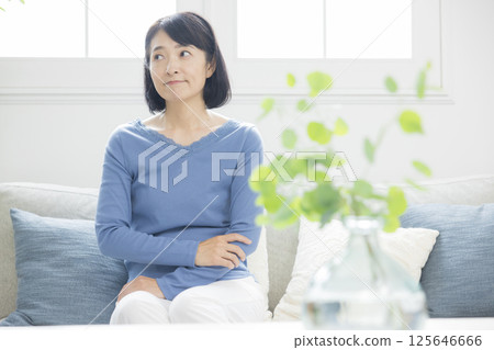 Middle woman worried in the living room Middle woman worried in the living room 125646666
