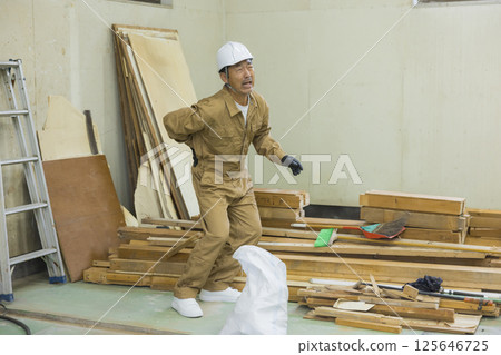 Worker at demolition site suffering from back pain 125646725